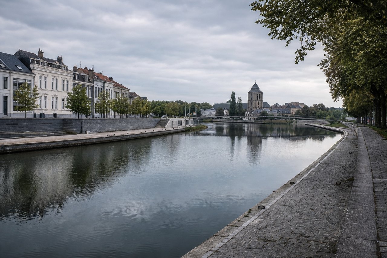 Moderne stenen kades langs de gekanaliseerde Leie door een Vlaamse stad
